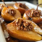Close-up view of baked pears topped with honey and walnuts.
