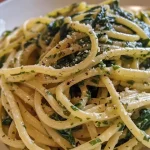 Close-up of creamy pasta dish with spinach and garlic topped with parsley.