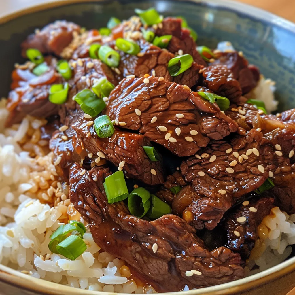 Side view of a bowl filled with white rice topped with juicy crispy beef and sesame seeds.