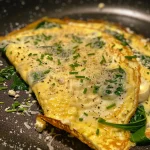 Close-up view of a fluffy keto spinach cheese omelet on a plate.