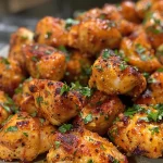 Close-up of juicy garlic butter chicken bites garnished with fresh parsley.
