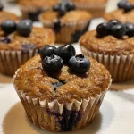 Side view of healthy blueberry muffins, showcasing their golden-brown tops and plump blueberries.