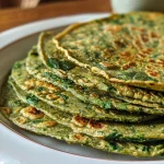 Close-up of healthy spinach tortillas on a wooden surface, showcasing their vibrant green color.