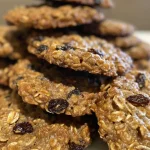 Close-up view of low-calorie oatmeal raisin cookies with golden edges and soft centers.