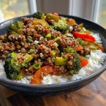 Close-up view of a colorful Spicy Ground Beef Stir-Fry Bowl with fresh vegetables and white rice.