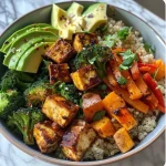 Close-up view of a vibrant spiced tofu quinoa bowl with colorful veggies.