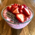 Close-up of creamy strawberry chia pudding with fresh strawberry chunks.