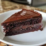 Close-up view of a decadent gluten-free chocolate cake with rich frosting.