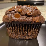 Close-up of a moist double chocolate banana muffin with chocolate chips.