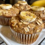 Close-up side view of moist banana muffins with a golden-brown crust.