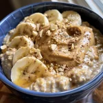 Close-up view of a bowl of Peanut Butter Banana Protein Overnight Oats topped with banana slices.