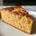 Side view of a moist Almond Flour Greek Yogurt Cake displayed on a plate.