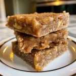 ['A close-up side view of a textured Apple Pie Protein Bar with visible apple chunks and a sprinkle of cinnamon.', 'An iPhone 15 Pro photo depicting a succulent Apple Pie Protein Bar, showcasing its layered ingredients and appealing surface.', 'Side view of a deliciously crafted Apple Pie Protein Bar, highlighting diced apples and spices within a soft texture.', 'Close-up image of a protein bar resembling apple pie, featuring pieces of apple and a dusting of cinnamon.']