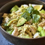 Close-up of a vibrant avocado chicken salad featuring diced avocados and shredded chicken.