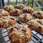 Close-up side view of golden-brown banana coconut cookies on a plate.