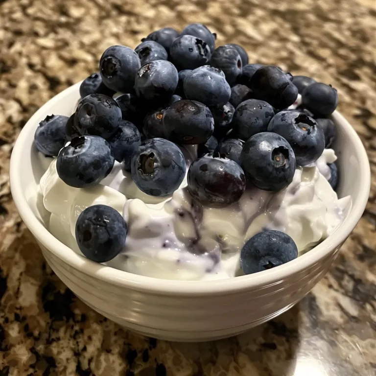 Delightfully Chilled Blueberry Yogurt Clusters for Every Sweet Tooth Close-up view of blueberry yogurt clusters with fresh blueberries on a plate.