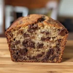 Close-up view of a slice of moist chocolate chip banana bread.