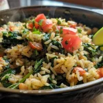 ['A close-up side view of a bowl of spinach rice with diced tomatoes and garnished with lime.', 'Juicy spinach rice dish in a bowl, showcasing vibrant green spinach and colorful diced tomatoes.', 'One pot spinach rice dish seen from the side, featuring fresh spinach, beans, and garnishes.', 'Delicious Easy Healthy One Pot Spinach Rice in a rustic bowl, highlighting its colorful ingredients.']