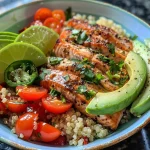 ['Close-up of a Garlic Herb Salmon Bowl featuring salmon, quinoa, and fresh vegetables.', 'Side view of a colorful bowl with garlic herb salmon, avocado, and cherry tomatoes.', 'Detailed shot of Garlic Herb Salmon Bowl showcasing salmon fillets and vibrant toppings.', 'A vibrant meal with salmon, quinoa, and assorted toppings in a deep bowl.']