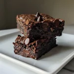 ['Close-up view of moist gluten-free almond flour brownies, showcasing a rich chocolate texture.', 'Side view of decadent gluten-free brownies made with almond flour and topped with chocolate chips.', 'Juicy, chocolatey gluten-free brownies, highlighting their fudgy interior and almond flour composition.', 'Tasty gluten-free almond flour brownies, emphasizing their dark color and glossy surface.']