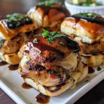 ['Close-up view of Greek chicken sliders topped with spicy feta dip on a wooden board.', 'Side view of juicy Greek chicken sliders with melted mozzarella and fresh scallions.', 'A platter of Greek chicken sliders with a dollop of tirokafteri dip and balsamic drizzle.', 'Juicy sliders made with spatchcocked chicken and served on Hawaiian rolls.']