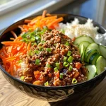 ['Close-up view of a ground turkey rice bowl topped with guacamole and pico de gallo.', 'Side view of a colorful rice bowl featuring ground turkey, corn, beans, and cheese.', 'Juicy ground turkey rice bowl garnished with fresh cilantro and lime wedges.', 'Delicious ground turkey served over cilantro lime rice with sour cream and lettuce.']