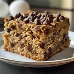 ['Close-up view of a Healthy Chocolate Chip Oat Cake with a golden-brown crust and dark chocolate chips.', 'Side view of a moist Healthy Chocolate Chip Oat Cake showcasing its fluffy texture and chocolate chunks.', 'Detailed shot of a slice of Healthy Chocolate Chip Oat Cake highlighting the oat and chocolate mix.', 'Vibrant image of a Healthy Chocolate Chip Oat Cake displaying its rich color and ingredients.']