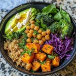 A colorful High Protein Buddha Bowl featuring quinoa, chickpeas, sweet potatoes, and broccoli.