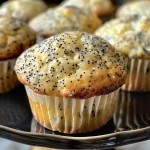 ['Close-up of a golden brown lemon poppy seed muffin with blueberries.', 'Side view of a lemon poppy seed muffin showing texture and blueberries.', 'Juicy lemon poppy seed muffin with a moist interior, garnished with lemon zest.', 'Delicious muffin with poppy seeds and bright blueberries, resting on a plate.']
