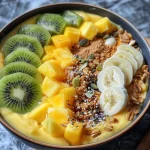 ['Close-up view of a vibrant mango pineapple smoothie bowl topped with fresh fruit and granola.', 'Side view of a colorful smoothie bowl featuring mango, pineapple, and various toppings.', 'Detailed shot of a smoothie bowl with a creamy mango-pineapple blend and kiwi slices on top.', 'Artistic view of a smoothie bowl filled with tropical fruits and nuts, showcasing its texture and colors.']
