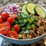 ['A vibrant Mediterranean bowl featuring ground turkey and quinoa with fresh vegetables.', 'Close-up view of a colorful bowl containing quinoa, ground turkey, diced cucumbers, and cherry tomatoes.', 'A delicious Mediterranean dish showcasing ground turkey, quinoa, and garnished with parsley and lemon.', 'A side view of a Mediterranean bowl filled with quinoa, ground turkey, and assorted fresh vegetables.']
