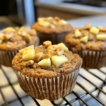 ['Close-up of a golden-brown Protein Apple Muffin with visible apple chunks and a sprinkle of cinnamon.', 'Side view of a moist Protein Apple Muffin showcasing grated apples and a soft texture, on a wooden background.', 'Delicious Protein Apple Muffin highlighting its fluffy interior with diced apples, set against a neutral backdrop.', 'Freshly baked Protein Apple Muffins arranged neatly, emphasizing their healthy ingredients and enticing appearance.']