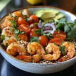 ['A close-up view of a colorful quinoa bowl topped with shrimp and fresh vegetables.', 'A vibrant quinoa bowl featuring shrimp, avocado, cherry tomatoes, and garnished with cilantro.', 'Side view of a delicious quinoa bowl filled with shrimp, diced avocado, and fresh veggies.', 'A delicious, colorful dish of quinoa with shrimp and various toppings in a bowl.']
