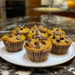['A close-up side view of healthy pumpkin chocolate chip muffins showcasing their moist texture and chocolate chips.', 'Side profile of freshly baked pumpkin chocolate chip muffins highlighting their golden-brown tops and chocolate pieces.', 'Juicy pumpkin chocolate chip muffins displayed in a vibrant setting, emphasizing their soft and fluffy interiors.', 'A tempting side view of healthy muffins filled with chocolate chips and pumpkin, ready to be enjoyed.']