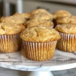 ['Close-up side view of a golden-brown vanilla muffin with a fluffy texture.', 'Juicy vanilla muffin displaying a soft crumb and a light crust on the side.', 'Delicious vanilla muffin with a moist interior, captured in detailed side view.', 'Side profile of a freshly baked vanilla muffin highlighting its golden exterior.']