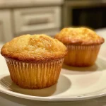 Close up side view of a golden brown vanilla muffin with a soft texture.