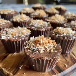 ['Close-up view of Vegan Coconut Cups topped with shredded coconut.', 'Side view of Vegan Coconut Cups showcasing their creamy texture and coconut flakes.', 'Juicy Vegan Coconut Cups displayed on a plate, highlighting their rich cocoa layers.', 'Eye-level shot of Vegan Coconut Cups revealing a luscious filling and coconut garnish.']