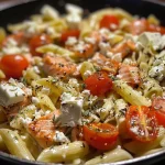['Close-up of Baked Feta Pasta with Salmon, showcasing creamy feta and cherry tomatoes.', 'Side view of a dish featuring Baked Feta Pasta topped with pieces of salmon and fresh herbs.', 'Juicy Baked Feta Pasta with salmon, cherry tomatoes, and garlic in a vibrant presentation.', 'Delicious plate of Baked Feta Pasta, highlighting cooked salmon and a block of feta cheese.']