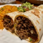 ['A close-up side view of a juicy beef burrito with visible ingredients and textures.', 'A detailed view of a beef burrito, showcasing the filling and tortilla.', 'A succulent beef burrito with cheese melting out, captured at an angle.', 'A vibrant beef burrito filled with seasonings, beans, and rice in a flour tortilla.']