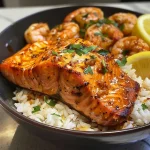 ['A close-up view of a Cajun Honey Garlic Salmon and Shrimp Rice Bowl featuring vibrant colors and textures.', 'A side view of a delicious rice bowl with juicy salmon and shrimp, garnished with parsley and lemon wedges.', 'A detailed shot of a salmon and shrimp rice bowl, showcasing glistening honey garlic sauce over jasmine rice.', 'A visually appealing bowl of Cajun Honey Garlic Salmon and Shrimp, with bright ingredients and rich colors.']