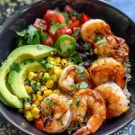 ['A colorful bowl filled with quinoa, shrimp, avocado, and fresh vegetables.', 'Close-up view of chili lime shrimp quinoa bowl showcasing vibrant ingredients.', 'A serving of quinoa topped with sautéed shrimp, diced avocado, and tomatoes.', 'A delicious bowl of chili lime shrimp with quinoa and garnishes.']