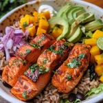 ['A close-up view of a colorful Chipotle Salmon Bowl featuring diced salmon, mango, avocado, and various toppings.', 'A side view of a delicious Chipotle Salmon Bowl, showcasing fresh salmon cubes and vibrant ingredients like avocado and cilantro.', 'A detailed close-up of a Chipotle Salmon Bowl filled with salmon, corn, lettuce, and garnished with lime and cilantro.', 'A visually appealing Chipotle Salmon Bowl featuring salmon, diced mango, jalapeno, and a variety of fresh toppings.']