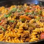 ['Close-up of creamy Southwestern Chipotle Beef Pasta with cavatappi and colorful toppings.', 'A savory plate of creamy beef pasta featuring sliced poblano peppers and melted cheese.', 'Juicy Southwestern Chipotle Beef Pasta arranged in a bowl, showcasing its creamy texture and vibrant ingredients.', 'Side view of a dish filled with cavatappi pasta, ground beef, and green peppers in a creamy chipotle sauce.']