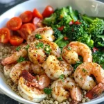 ['A close-up side view of a Garlic Lemon Shrimp Quinoa Power Bowl featuring shrimp, quinoa, and fresh vegetables.', 'A vibrant Garlic Lemon Shrimp Quinoa Power Bowl with colorful ingredients like shrimp, cherry tomatoes, and spinach.', 'Detailed side view of a bowl filled with Garlic Lemon Shrimp, quinoa, and assorted fresh vegetables.', 'A beautifully arranged Garlic Lemon Shrimp Quinoa Power Bowl brimming with shrimp, quinoa, and bright veggies.']