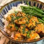 ['Close-up of a colorful Honey Mustard Chicken Bowl featuring juicy chicken chunks, green beans, and fluffy jasmine rice.', 'Side view of a delicious Honey Mustard Chicken Bowl with golden chicken pieces, vibrant green beans, and rice on a wooden table.', 'Detailed shot of Honey Mustard Chicken Bowl showcasing tender chicken, fresh green beans, and jasmine rice in a rustic bowl.', 'Close-up of a vibrant Honey Mustard Chicken Bowl filled with marinated chicken, green beans, and white rice, garnished with herbs.']