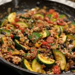 ['Close-up of a Mediterranean turkey skillet with farro, zucchini, and cherry tomatoes.', 'Side view of a colorful turkey and farro dish, garnished with parsley.', 'Juicy Mediterranean turkey skillet featuring roasted zucchini and spinach.', 'Close-up of a vibrant turkey and farro meal with lemon zest on top.']
