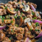 ['Close-up of a juicy mustard beef dish with mushrooms and red onions.', 'A side view of tender ground beef mixed with mushrooms, garnished with parsley.', 'Detailed shot of mustard beef with Portobello mushrooms and sliced onions.', 'A vibrant plate featuring cooked mustard beef and fresh herbs.']