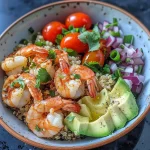 ['Close-up view of a quinoa bowl with shrimp, cherry tomatoes, avocado, and red onion.', 'Side photo of a colorful quinoa bowl featuring shrimp, diced avocado, and fresh cilantro.', 'Juicy quinoa bowl with large shrimp and vibrant vegetables, presented in a stylish dish.', 'A hearty quinoa bowl displaying shrimp, tomatoes, and avocado, garnished with cilantro.']