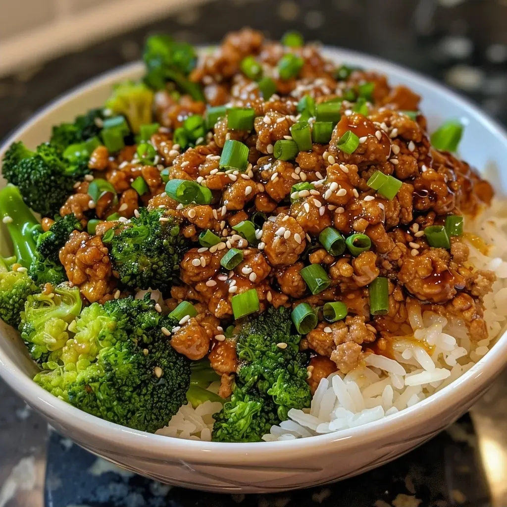 ['Close-up view of a delicious Teriyaki Turkey Rice Bowl featuring ground turkey and broccoli over rice.', 'Side view of a vibrant Teriyaki Turkey Rice Bowl with steamed broccoli and ground turkey on a bed of rice.', 'Juicy Teriyaki Turkey Rice Bowl with colorful broccoli, ground turkey, and fluffy rice in a close-up shot.', 'Appetizing Teriyaki Turkey Rice Bowl showcasing tender turkey meat, bright broccoli, and rice.']