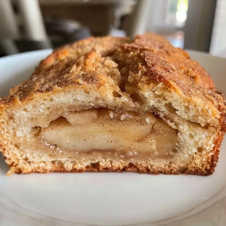 ['Close-up view of a loaf of apple cinnamon sourdough bread with a golden crust.', 'Side view of a freshly baked apple cinnamon sourdough bread showcasing its soft interior and chunks of apple.', 'Textured crust of apple cinnamon sourdough bread with visible pieces of apple and spices.', 'Juicy apple cinnamon sourdough bread displaying a rich brown crust and warm, fluffy interior.']